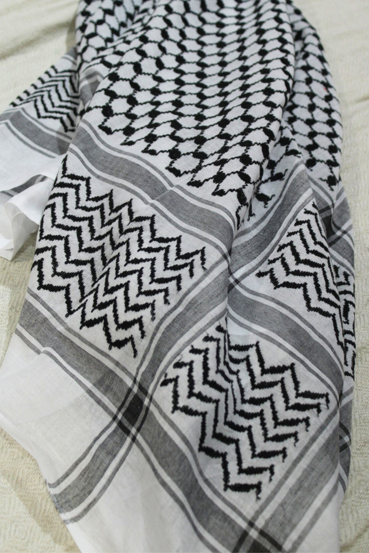 A Palestinian kuffiyeh, a square scarf with a black and white checkered pattern, symbolizes resilience, heritage, and solidarity in the struggle for justice and freedom
