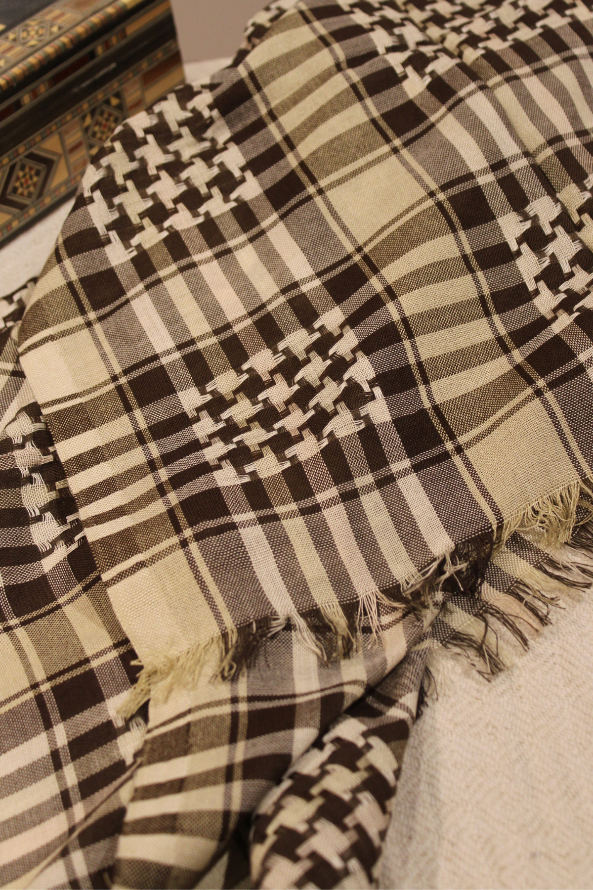 Detailed view of the unique patterns on the beige Kuffiyeh, highlighting artisan craftsmanship and cultural significance.