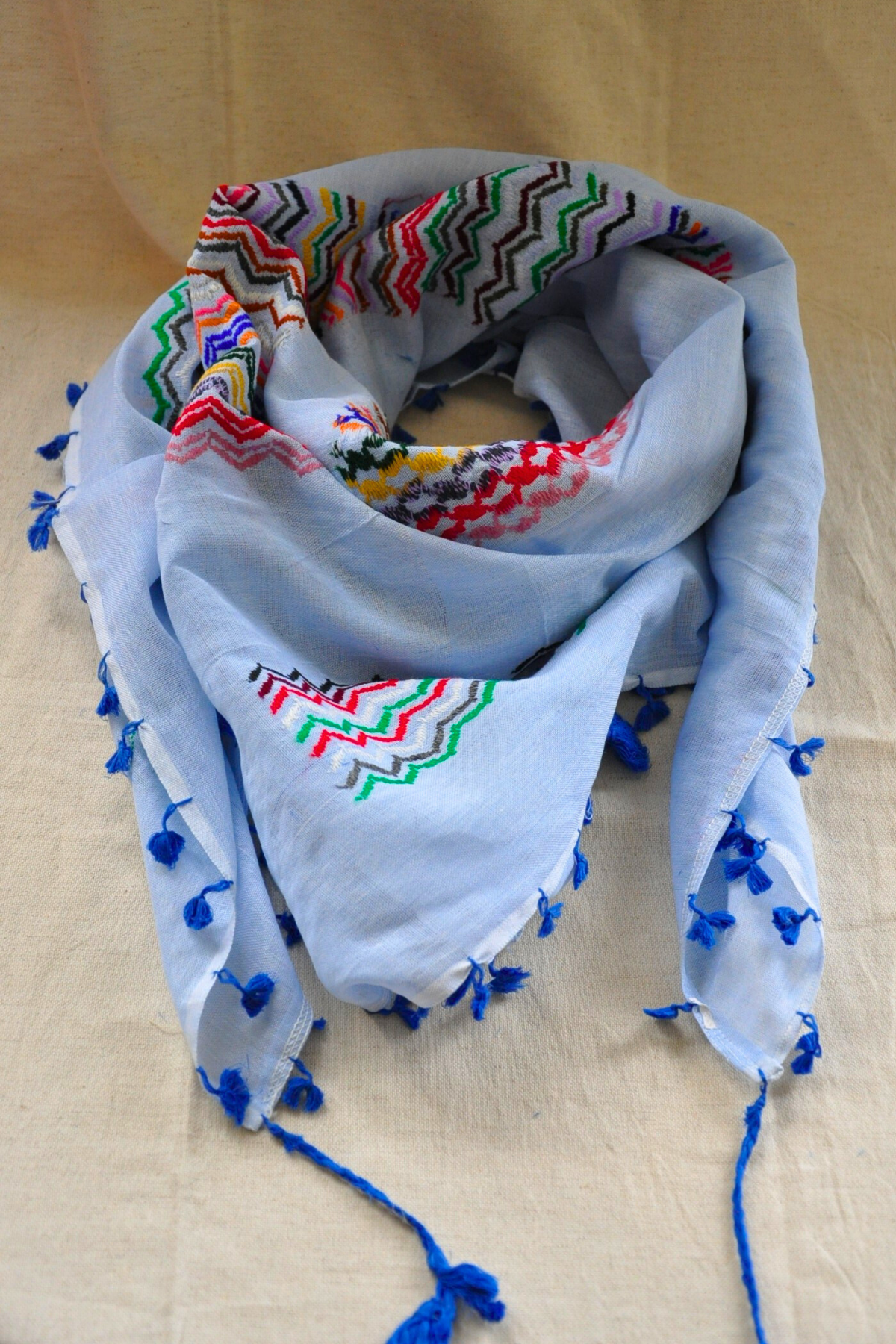 Detailed view of the vibrant patterns on the Light Blue Kuffiyeh scarf, emphasizing the blend of modern design and traditional craftsmanship.