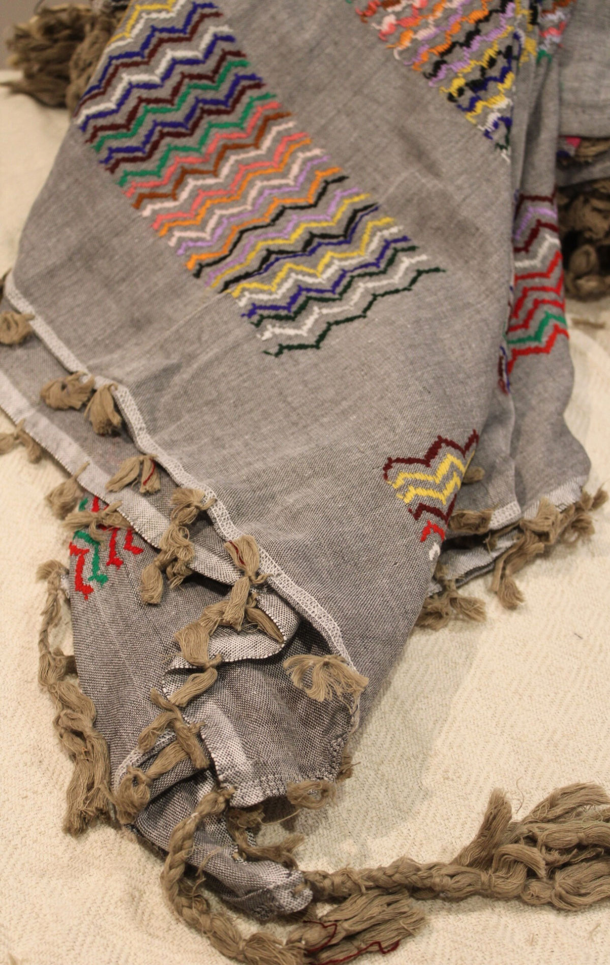 Detailed view of vibrant patterns on the Grey Kuffiyeh scarf, highlighting the seamless fusion of contemporary and traditional artistry.