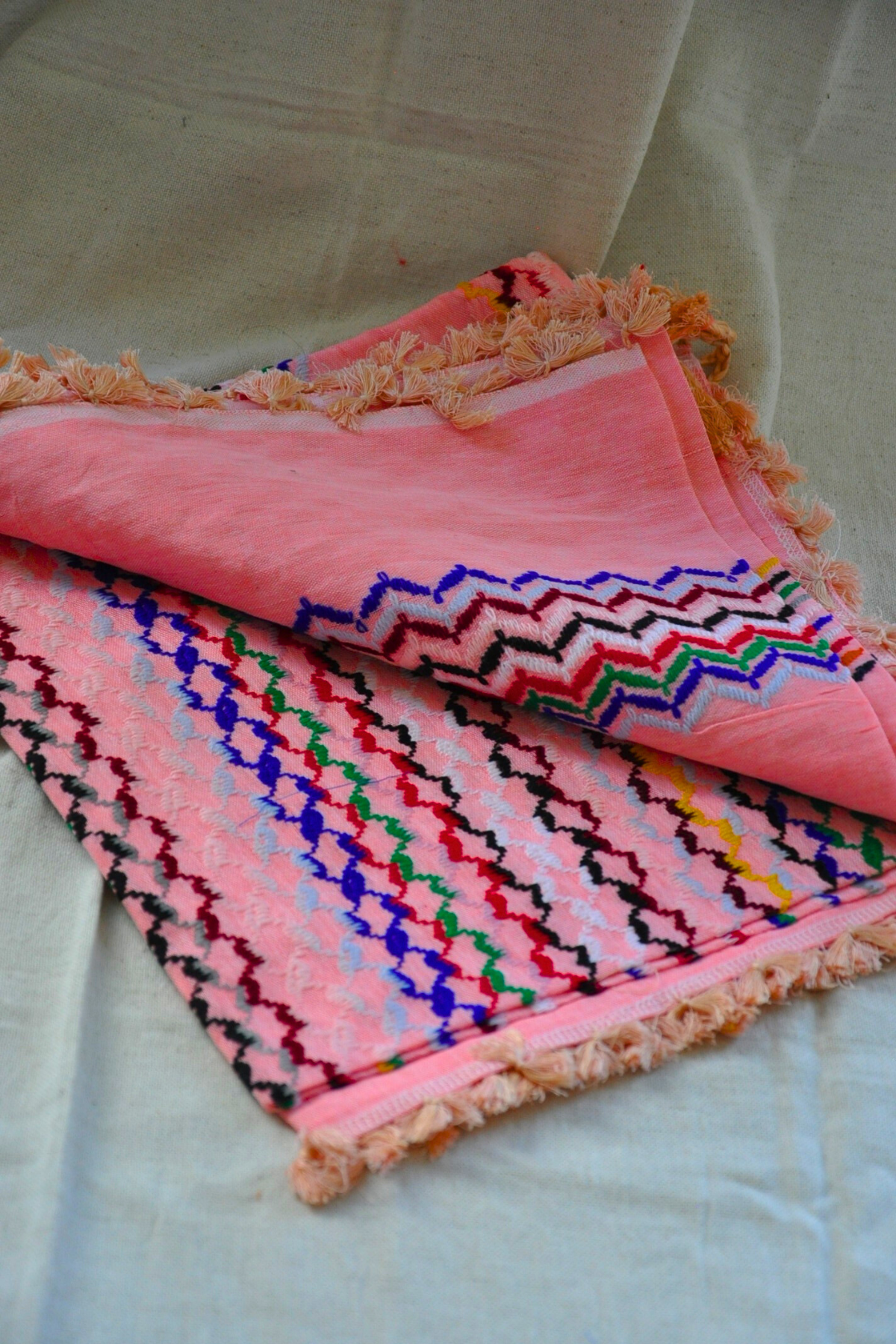 Peach Kuffiyeh scarf elegantly styled, demonstrating its versatility and the striking color palette that makes it perfect for any occasion.