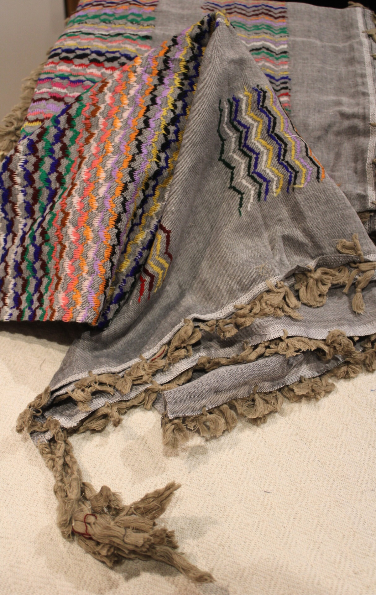 Grey Kuffiyeh scarf elegantly arranged, demonstrating its versatility and vibrant colors suitable for any occasion.