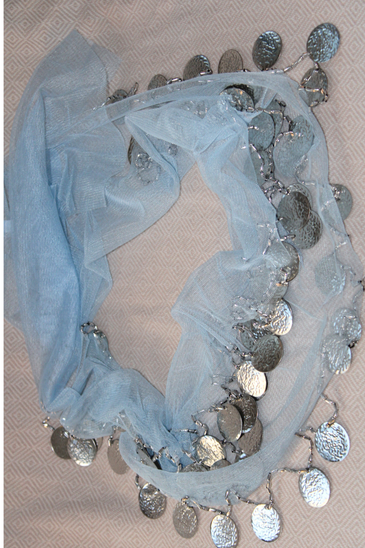 A soft light blue belly dance waist chain with two layers of silver coins. This calming, gentle color complements the shimmering silver coins, making it the perfect accessory for an elegant belly dancing performance.