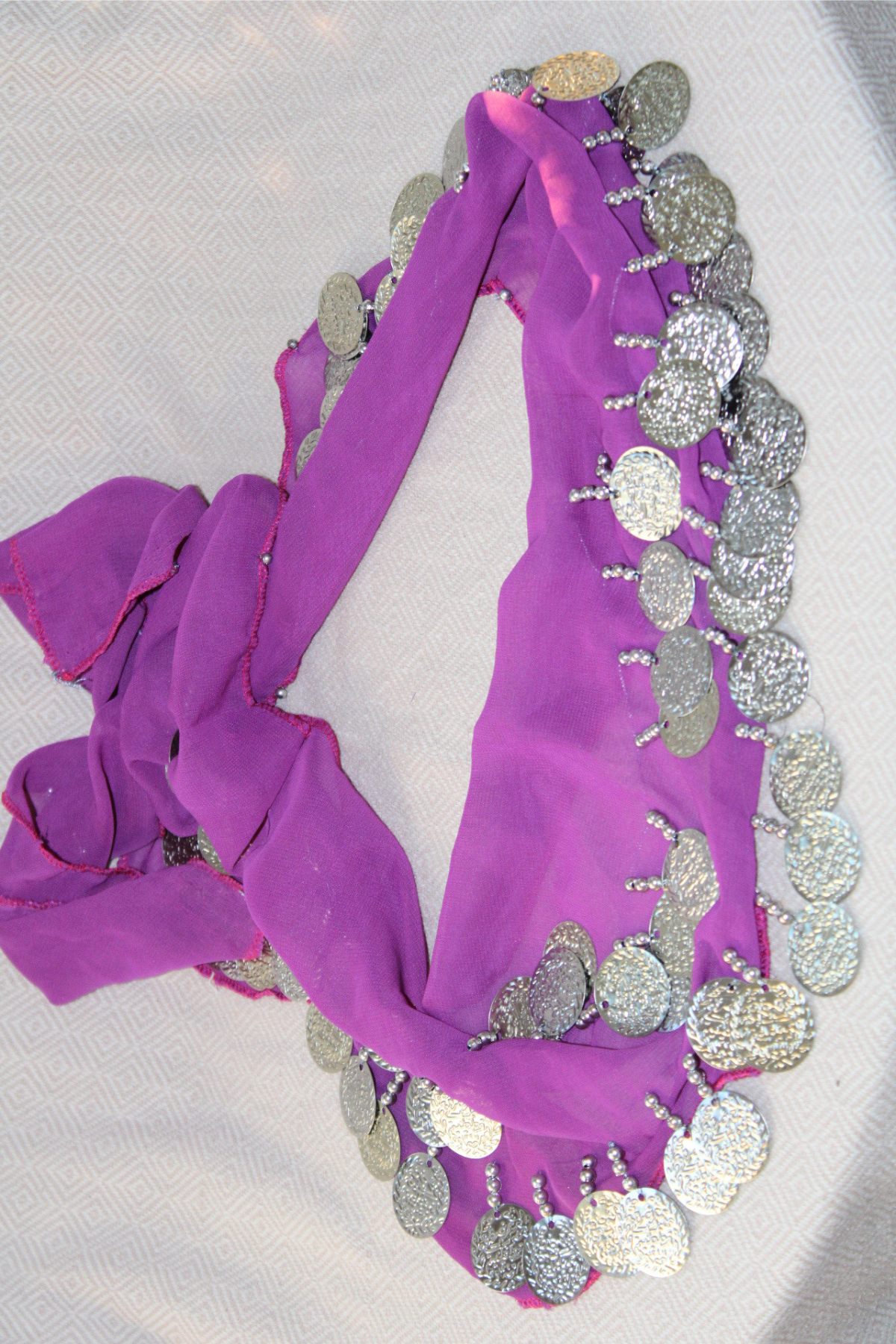 A rich purple belly dance waist chain with two layers of silver coins. This eye-catching waist scarf adds a touch of royalty and sophistication to your belly dancing performance.

