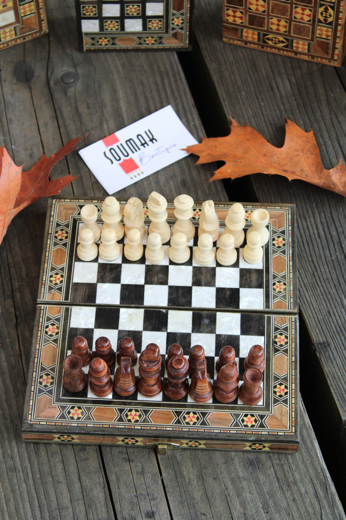 Chess side of the Mini Syrian Board adorned with intricately carved chess pieces, showcasing its unique black and white design.